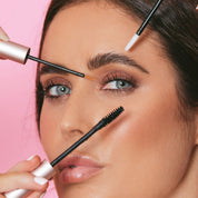 Model demonstrating Lash Therapy Australia lash growth serum, brow growth serum and mascara application on pink background.